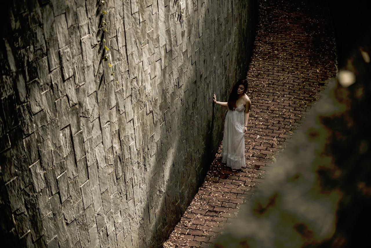 Woman facing a wall.
