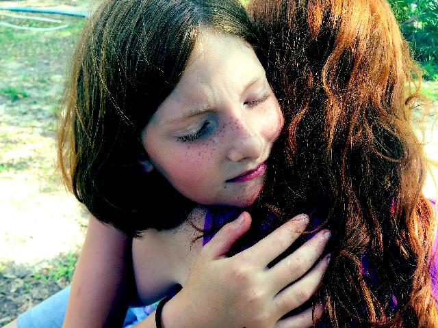 Girl hugging another girl with forgiving heart.